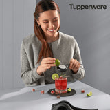 Woman using a citrus press to zest lime over a cocktail with Tupperware kitchen tool